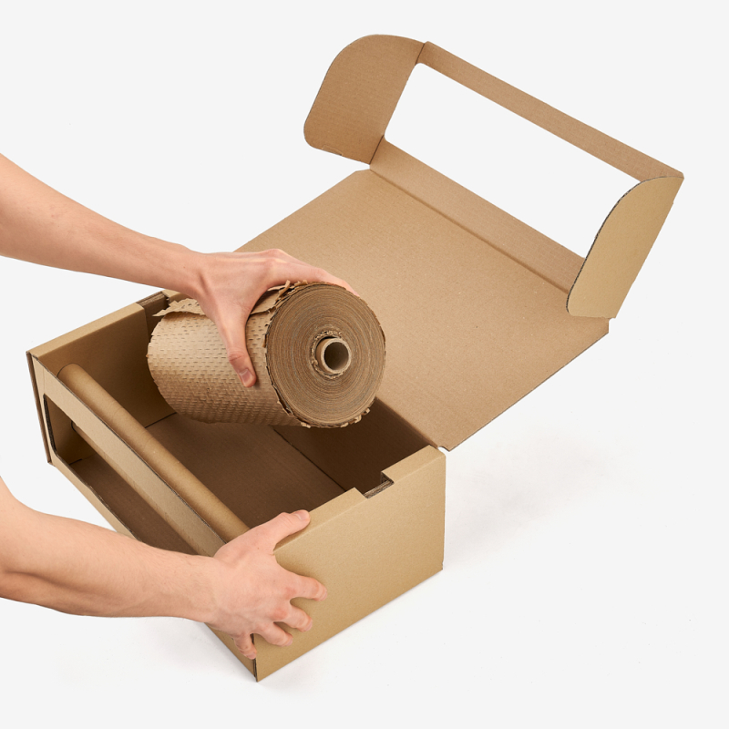 Rolle Wabenpapier wird in den Kartonspender für perforiertes Verpackungspapier eingelegt.