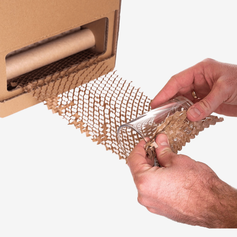 Herausziehen von Wabenpapier aus dem Spender und Einwickeln des Produkts.