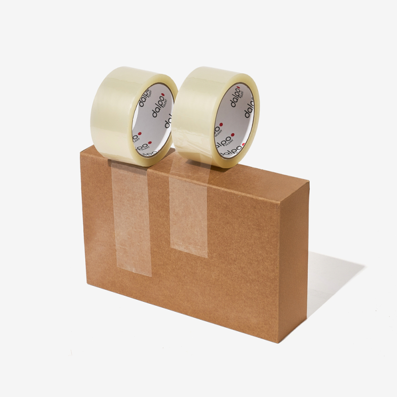 Zwei transparenten, geräuscharm abrollende Selbstklebebänder auf einem verschlossenen Versandkarton.