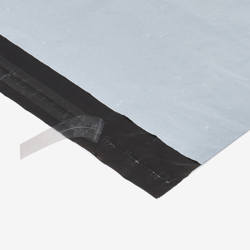 Nahaufnahme eines Versandbeutels aus Folie – Klebestreifen auf grauem Hintergrund