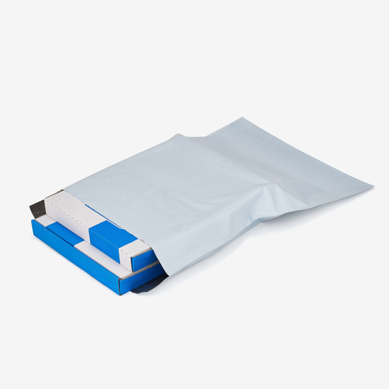 Druckerpapier verpackt in einem Versandbeutel aus Folie auf grauem Hintergrund