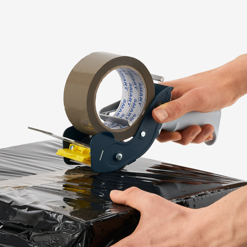 Metallabroller für Klebeband mit braunem Acrylklebeband in männlicher Hand gehalten