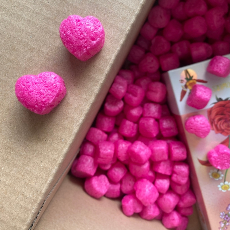 Fuchsiafarbener, biologisch abbaubarer Skropak - Füllmaterial für Pakete in Herzform.