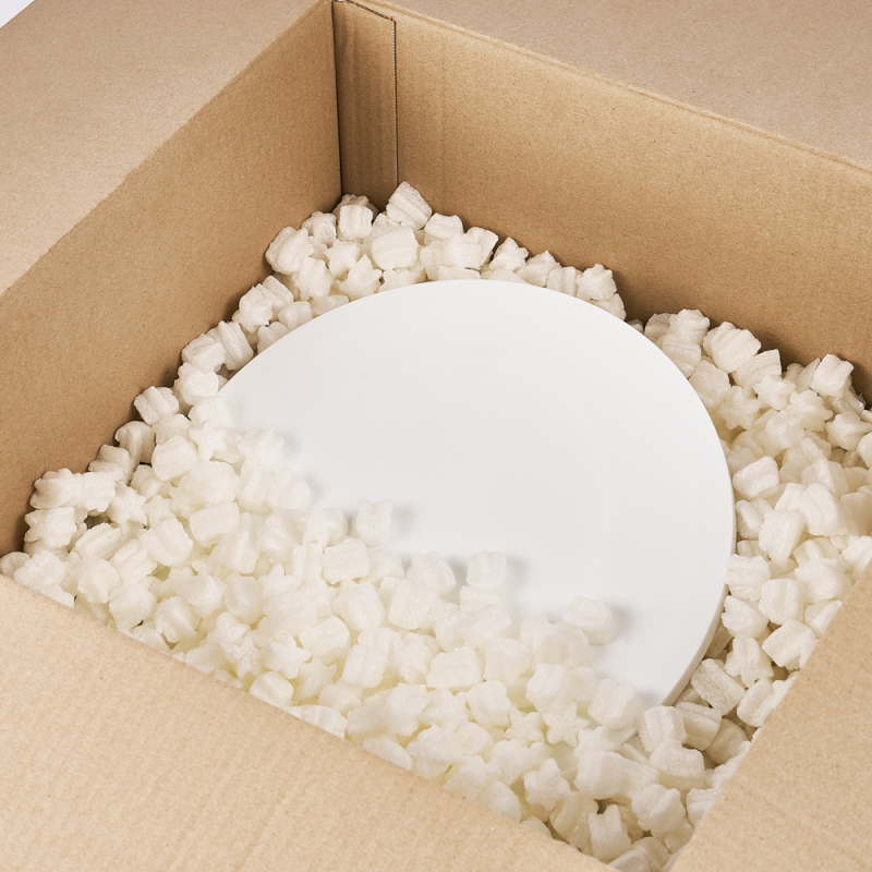 Teller in einem Karton verpackt - gesichert mit weißem Skropak in Sternchenform als Schutzfüllung.