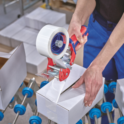 Mitarbeiter verwendet das transparente tesa® 4024 Klebeband zum Verschließen von Kartons auf einer Verpackungslinie.
