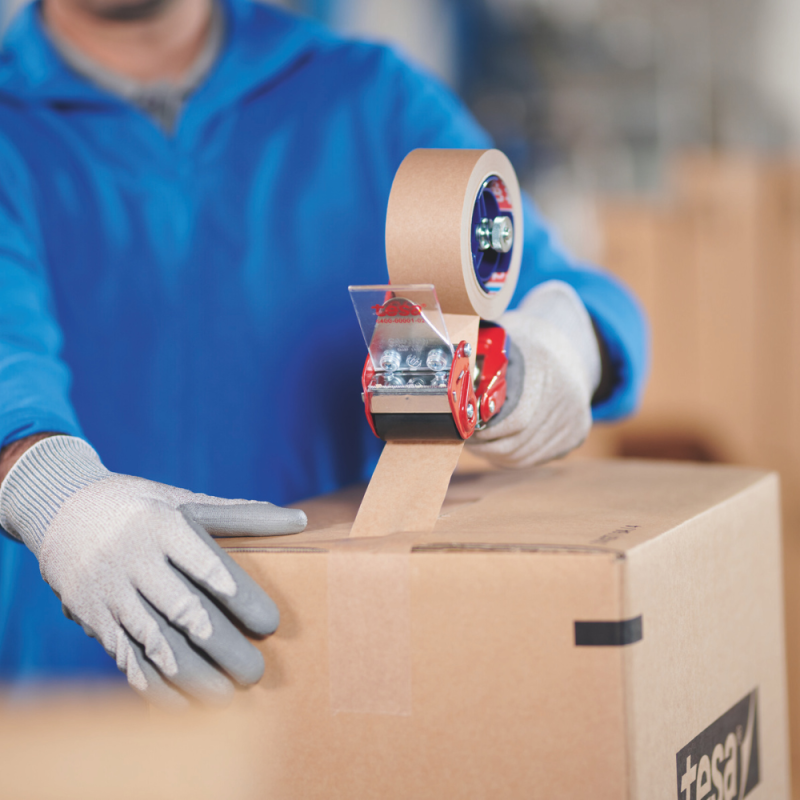 Ein Mitarbeiter verschließt einen Karton mit TESA® 4713 - Anwendung im täglichen Verpackungsprozess.