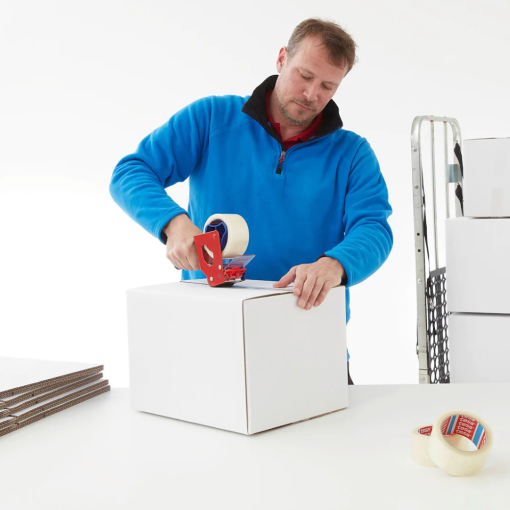 Ein Mitarbeiter verschließt präzise einen weißen Karton mit dem transparenten tesa® 4280 PV0.