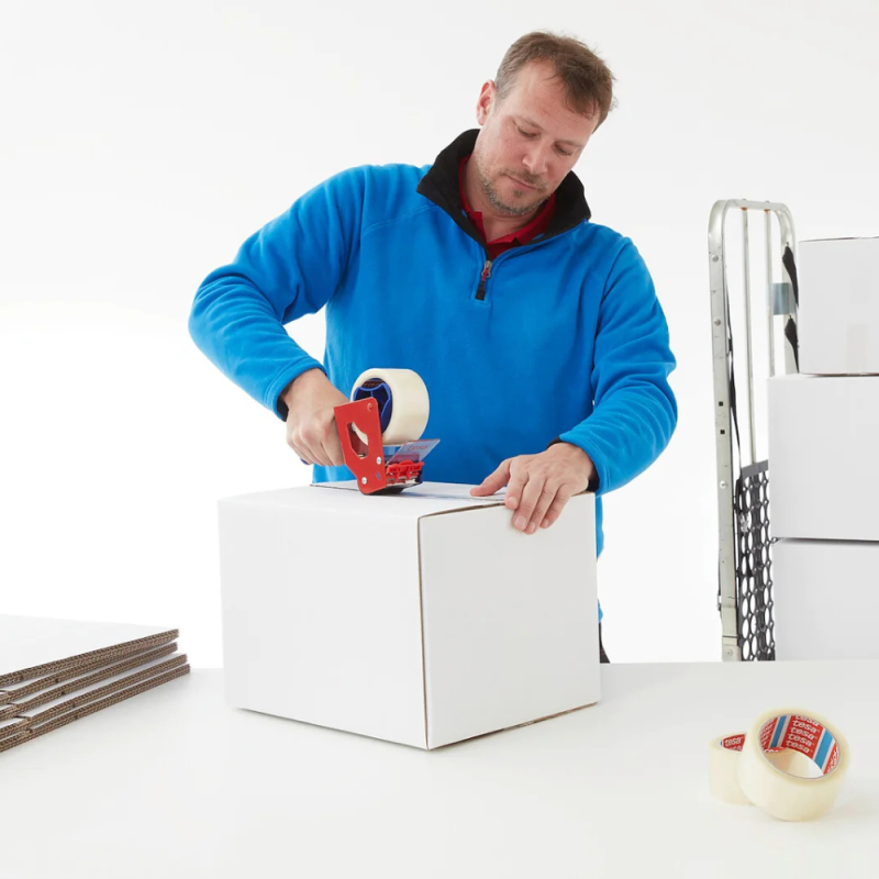 Ein Mitarbeiter verschließt präzise einen weißen Karton mit dem transparenten tesa® 4280 PV0.